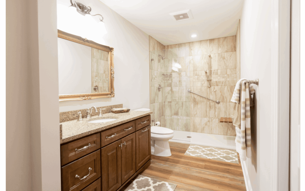 Remodeled bathroom with enough space for wheelchair accessibility, lower countertop, and walk-in shower with built-in seat and grab bars on wall.