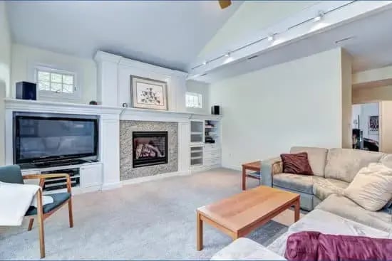 Family room remodel with fireplace, white walls, and tan carpeting