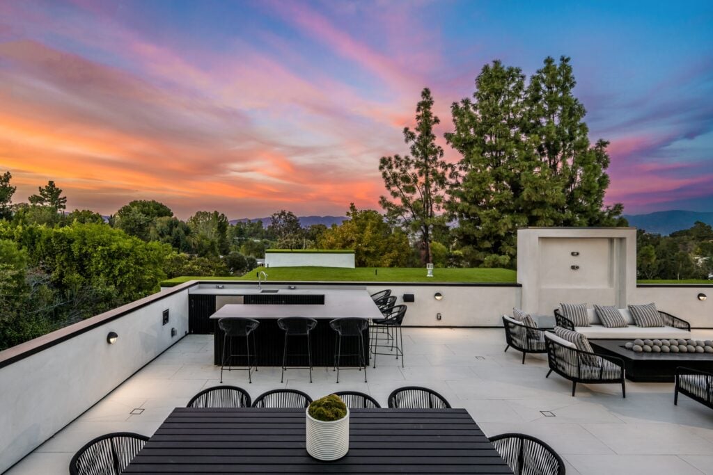 Scenic view of an outdoor patio surrounded by trees at sunset