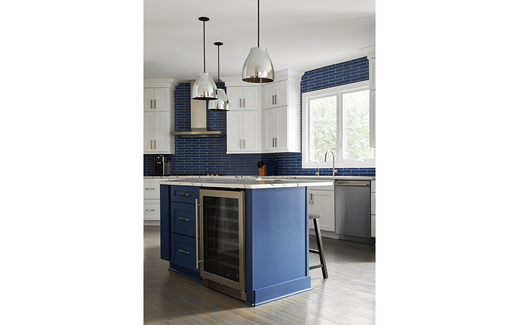 A custom kitchen remodel with blue subway tile backsplash and granite countertops. 