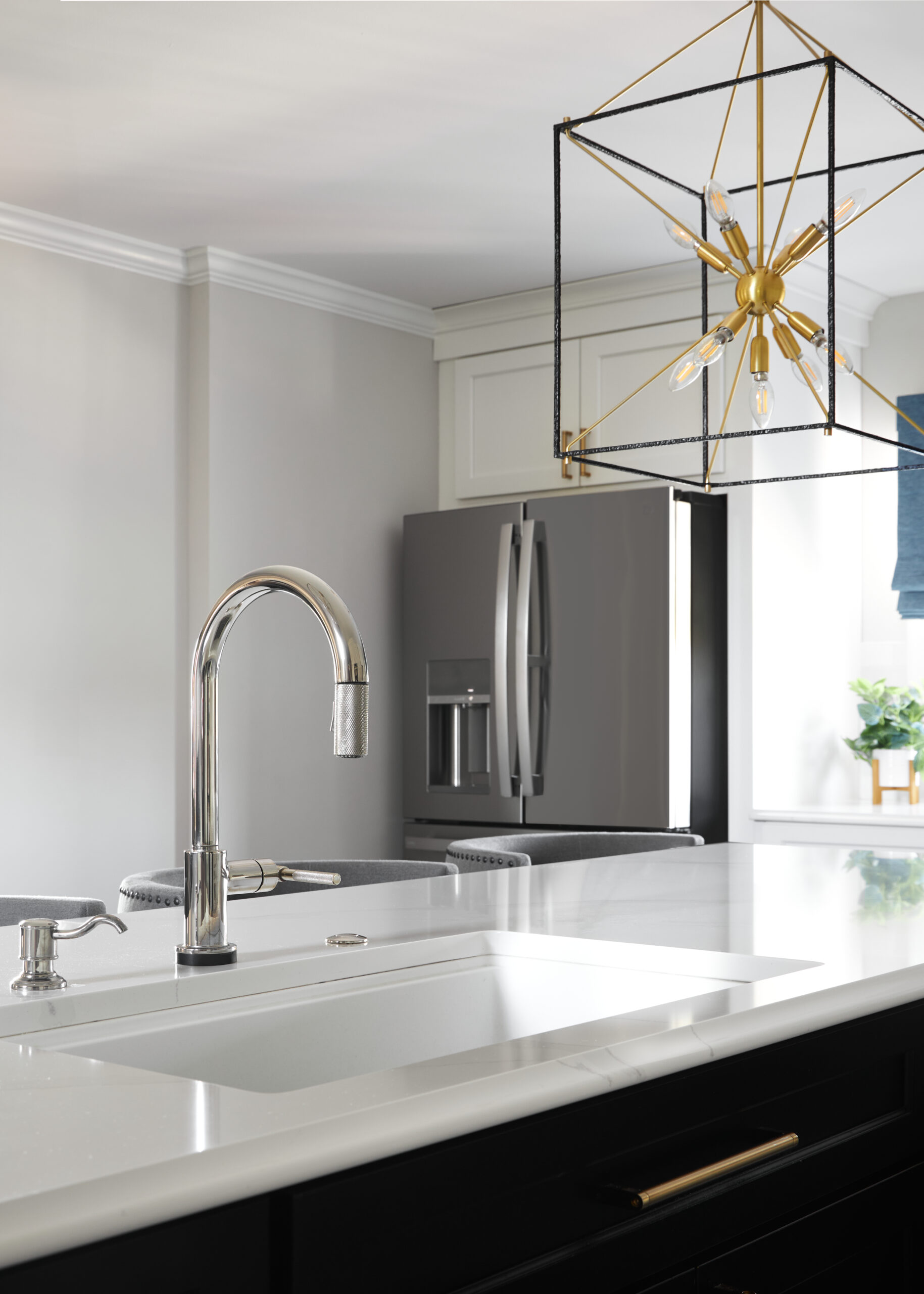 A redesigned kitchen with granite countertops and stainless steel sink faucet.