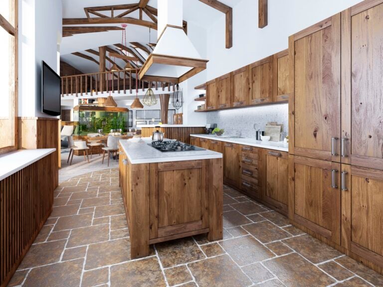 The large kitchen in the loft style with an island in the middle. Wooden furniture with white worktops and mosaic with integrated appliances.